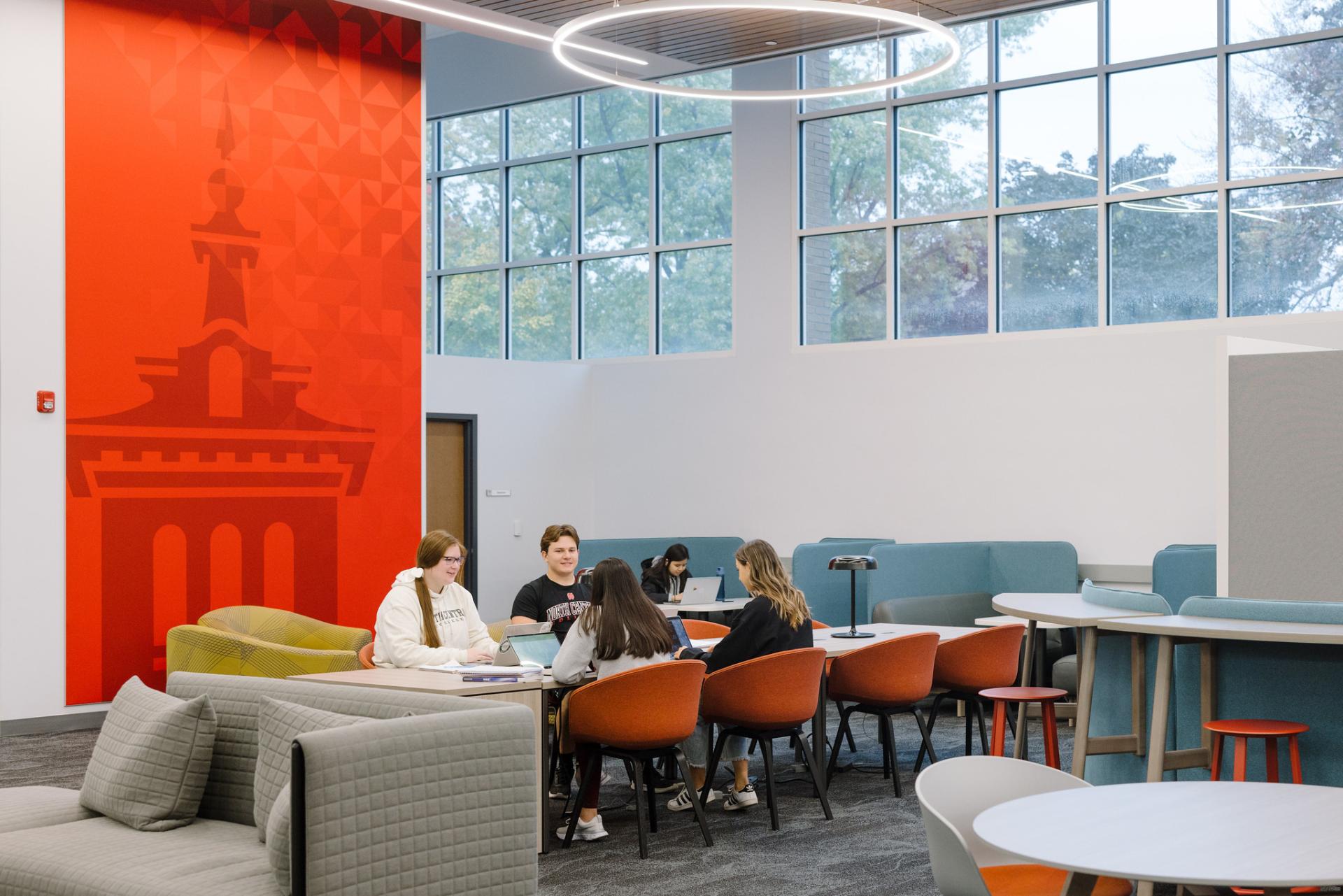 A photo of students working in Oesterle Library. They are sitting at a table.