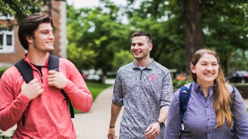 three students walking outside on campus